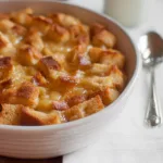 Close-up of pineapple casserole with bread in a white baking dish