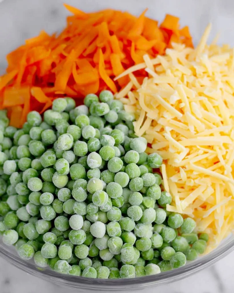 bowl of frozen peas, shredded carrot, and cheddar cheese