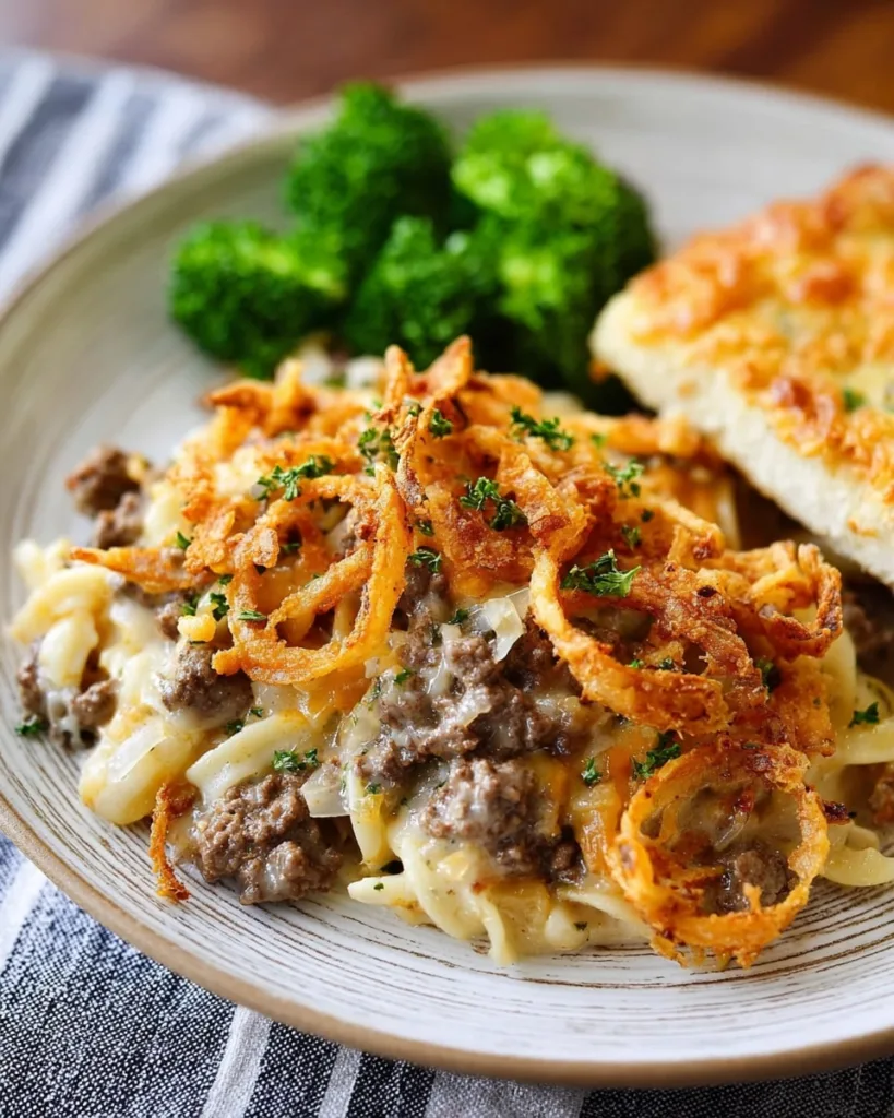 Serving of French Onion Casserole with broccoli and garlic bread on a plate